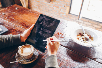Naklejka na ściany i meble Man shows screen of digital blank tablet device over a wooden with coffee