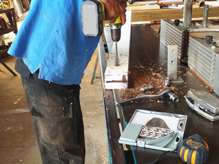 Carpentry workshop with milling machine, metal drill and tools for carving wood. Carpenter drilling...