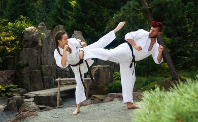 Para karateków walczących w parku.