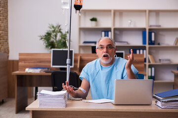 Old male employee in blood transfusion concept