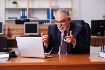Obraz premium Old male employee in gambling concept at workplace