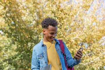 Happy boy looks at his phone one fall day