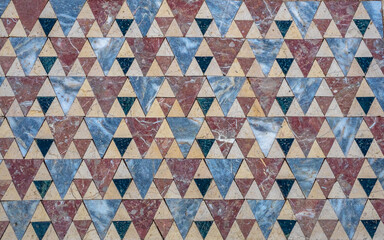 Fototapeta premium Stone floor with geometric pattern of triangular colored marble tiles.