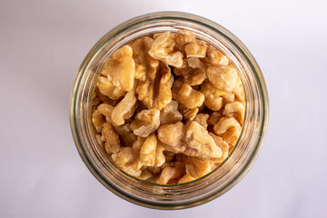 top view of jar with walnuts, isolated on white