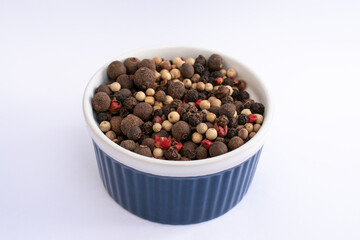 five pepper seeds on blue bowl isolated