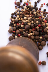 grinder with five peppers seeds isolated on white