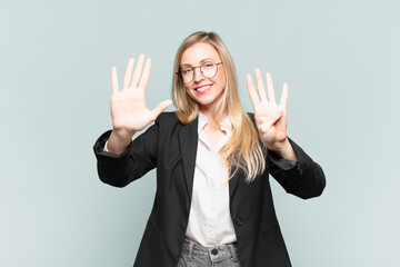 young pretty businesswoman smiling and looking friendly, showing number nine or ninth with hand...