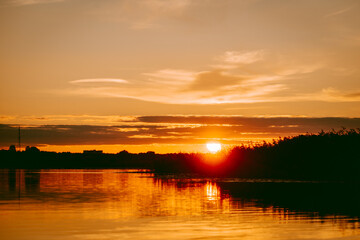 Colorful and intense sunset over the Lielupe river in Latvia during hot summer evening