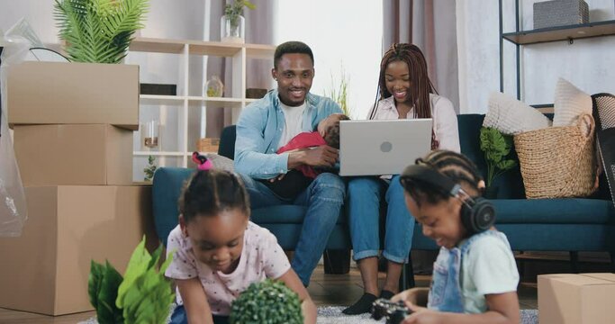 Attractive contented in high spirits young african american family with three small kids moved into new own dwelling and enjoying their feelings ,close up