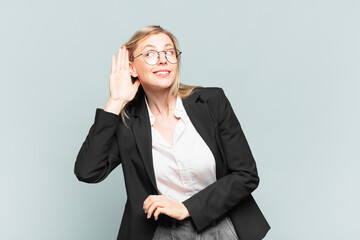 young pretty businesswoman looking serious and curious, listening, trying to hear a secret...
