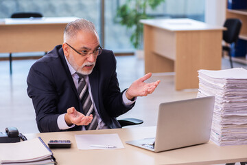 Aged businessman employee unhappy with excessive work