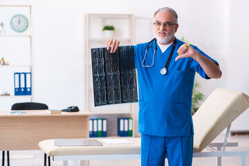 Old male doctor radiologist working in the hospital