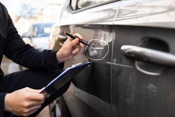 Insurance Agent Or Adjuster Inspecting Car