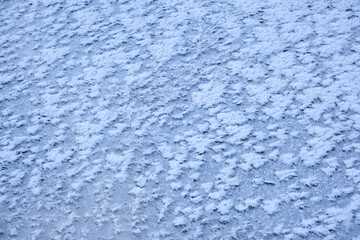Fototapeta na wymiar the texture of ice with snow in winter on the street
