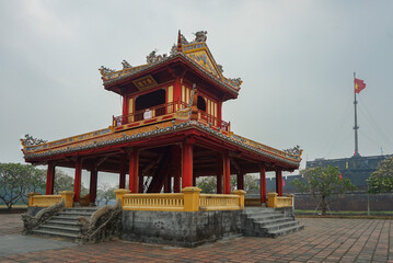 Colorful traditional pavilion with a flagpole in the background in Hue, Vietnam