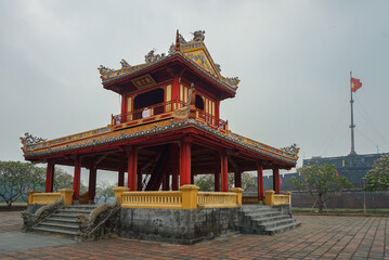 Fototapeta premium Colorful traditional pavilion with a flagpole in the background in Hue, Vietnam
