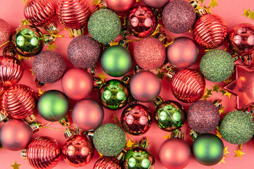 Green and red toy balls, and stars on a red paper background. Beautiful new year or christmas card top view