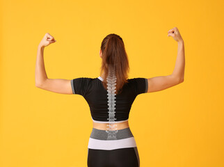 Sporty young woman with good posture on color background