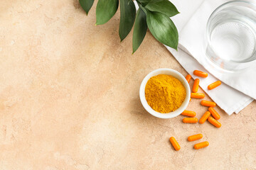 Turmeric pills and bowl with powder on color background