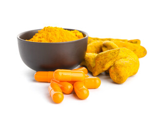 Turmeric pills and bowl with powder on white background