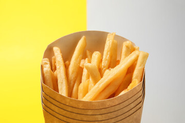 Boxes with tasty french fries on color background