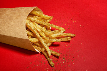 Glitters with tasty french fries on color background