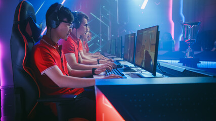 Diverse Esport Team of Pro Gamers Play in Mock-up FPS Shooter Video Game on a Championship. Stylish Neon Cyber Games Arena. Online Broadcasting of Tournament Event. © Gorodenkoff