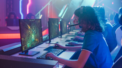 Pro Girl Plays Computer Game Plays RPG Strategy on a Championship. Diverse Esport Team of Pro Gamers Play in Mock-up Video Game. Stylish Neon Cyber Games Arena. Side View © Gorodenkoff