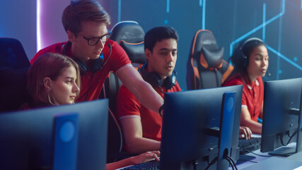 Diverse Esport Team of Pro Gamers Play in Video Game on a Championship, Talking Using Headsets, Trainer Explains Strategy. Stylish Neon Cyber Games Arena. Online Tournament Event © Gorodenkoff