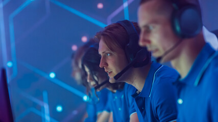 Professional Gamer Plays Computer Video Game Talking into Headset with Teammates on a Championship. Team of Pro Gamers Play in Computer Game. Stylish Neon Cyber Games Arena. Portrait Handheld View