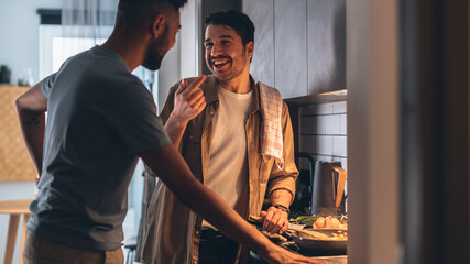 Happy Gay Couple Cooking Together in the Kitchen. Two Boyfriends in Love Spending Time Together....