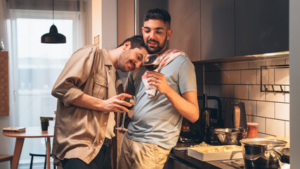 Happy Gay Couple Cooking Together in the Kitchen and Have Romantic Evening. Boyfriend Puts his Head on the Shoulder of His Love. Young Partners in Love, Talking, Having Fun.