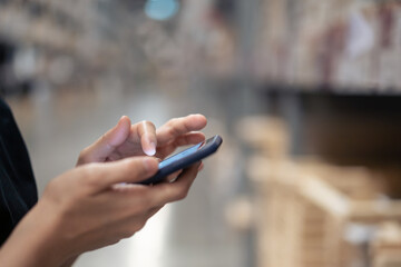 Woman using a smartphone when shopping in the store.