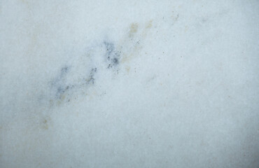 White Marble surface with brown, blue and other colored occlusions/imperfections, background with copy space