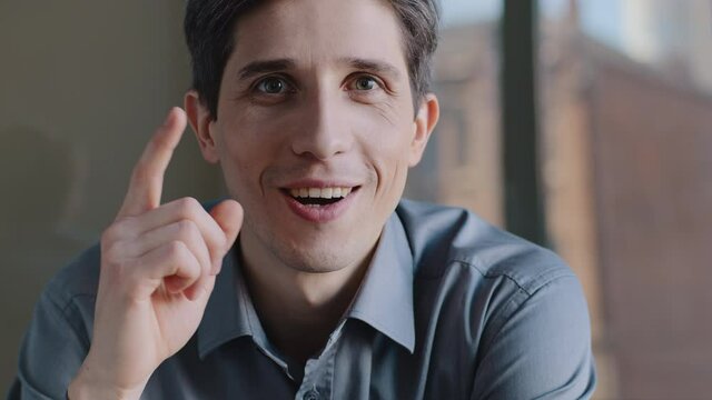 Close-up male pensive face, portrait caucasian puzzled business man professional sitting in office deep in thoughts, thinking recollecting memory, creating plan raises index finger, comes up with idea