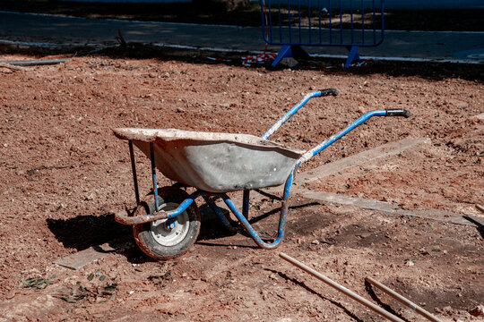Dirty wheelbarrow left by the worker is on the ground (511)