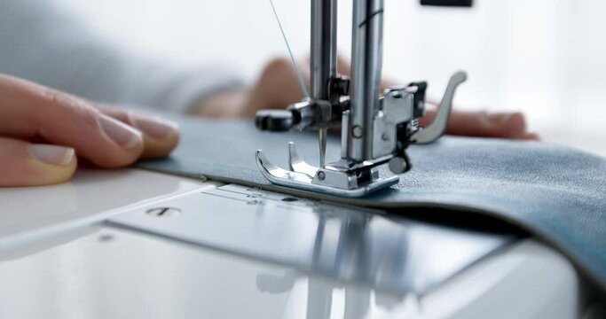 A seamstress works on a sewing machine. Needle and thread in slow motion. 4k