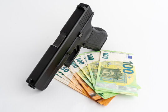 Gun and Euro banknotes on a white background. Symbols of crime in the darknet and real world. Cash money used as payment of a criminal. 