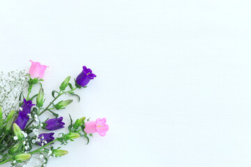 spring bouquet of purple, white and pink bell flowers over white background