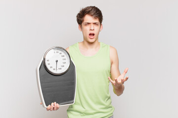 young boy looking angry, annoyed and frustrated screaming wtf or what’s wrong with you scale...