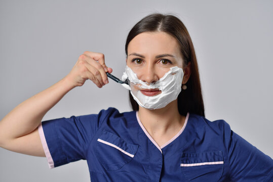 Woman with shaving foam on face and disposable razor
