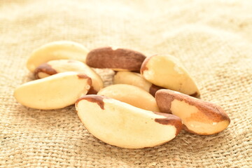 Several ripe organic Brazil nuts, close-up, on burlap.
