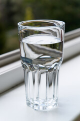 glass of water at the window sill 