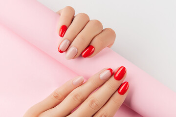 Womans hands with red modern manicure over white background. Manicure design trends