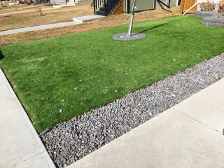 A beautiful artificial lawn in the front yard shining a healthy green in winter while other lawns...