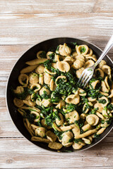 Wholemeal pasta with spinach in a pan. View from top.