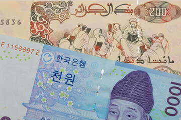 A macro image of a blue and white one thousand won bill from Korea paired up with a beige 200 Algerian dinar bank note.  Shot close up in macro.
