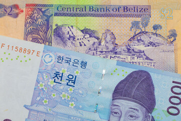 A macro image of a blue and white one thousand won bill from Korea paired up with a colorful two dollar bill from Belize.  Shot close up in macro.