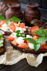 Tomato and mozzarella sandwich with fresh basil leaves