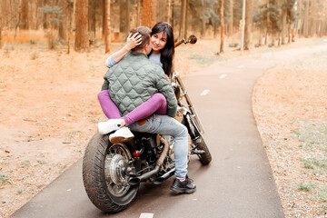 Obraz na płótnie Canvas guy with a girl in the park on a motorcycle